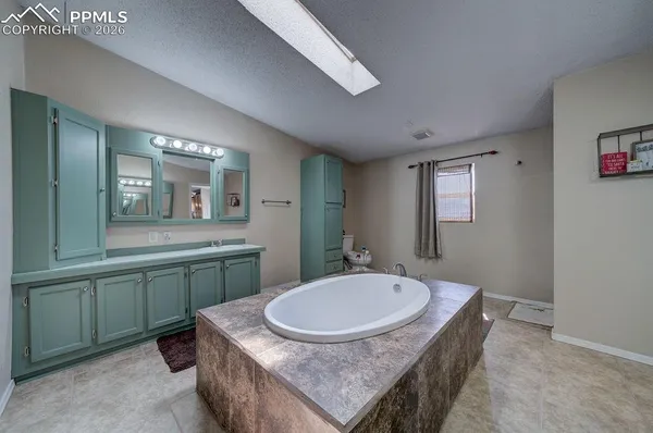 a bathroom with a granite countertop sink a mirror and a toilet