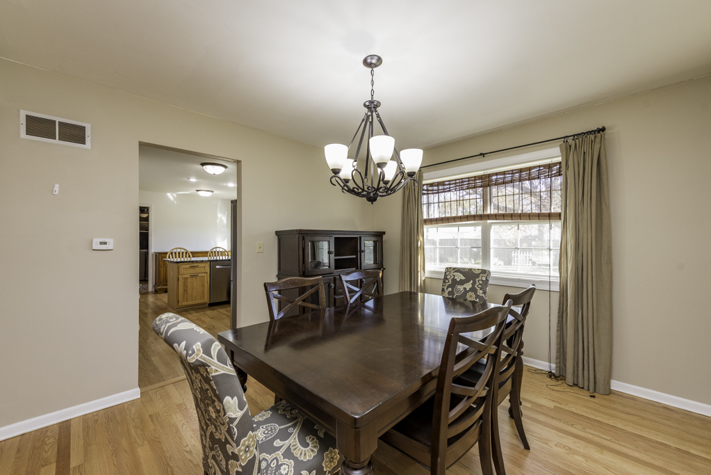 419 Northgate Road Lindenhurst, IL 60046 - Photo 4 of 23 a dining room with furniture a chandelier and wooden floor