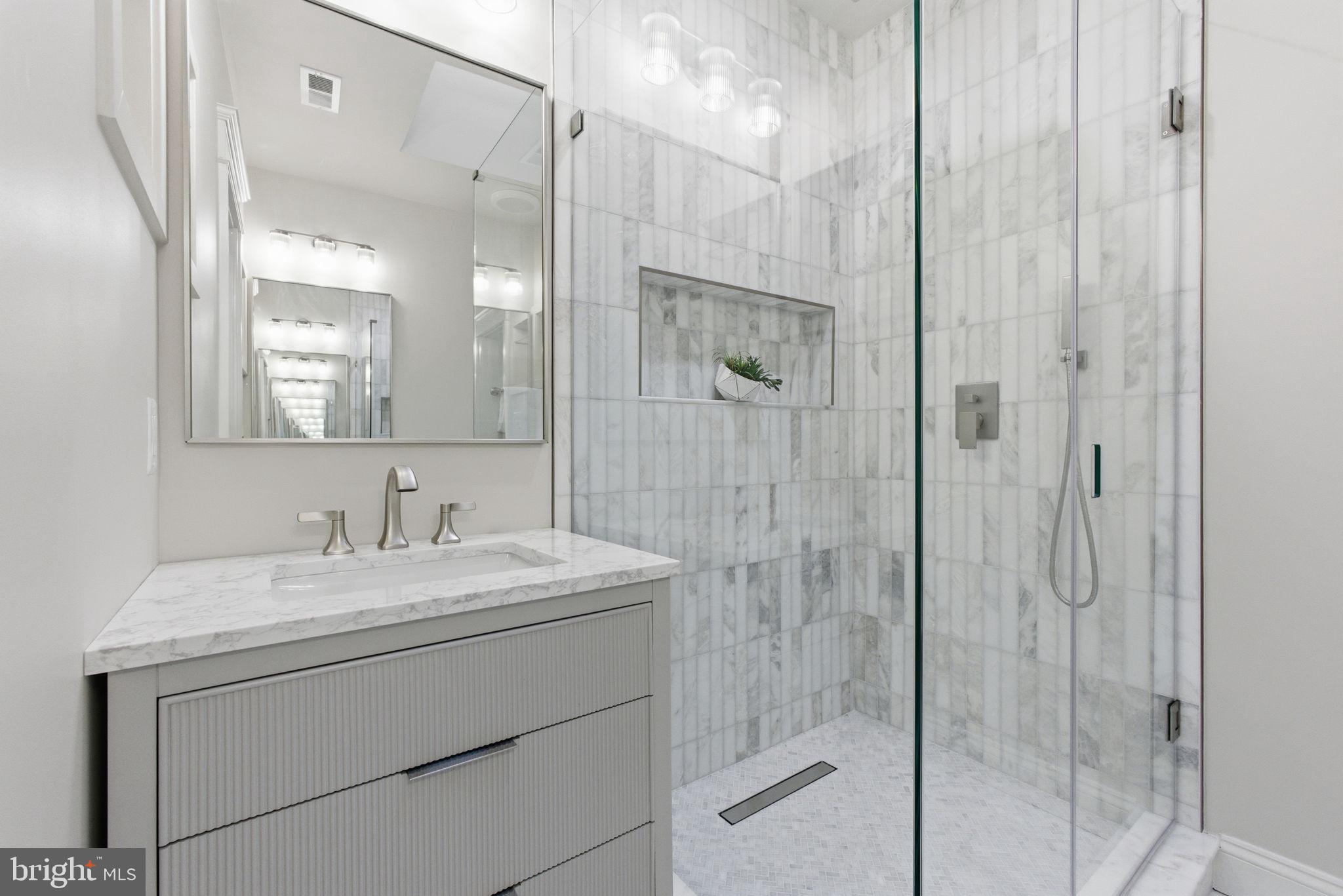 1319 East Capitol Street Southeast Washington, DC 20003 - Photo 21 of 46 a bathroom with a shower sink vanity and mirror
