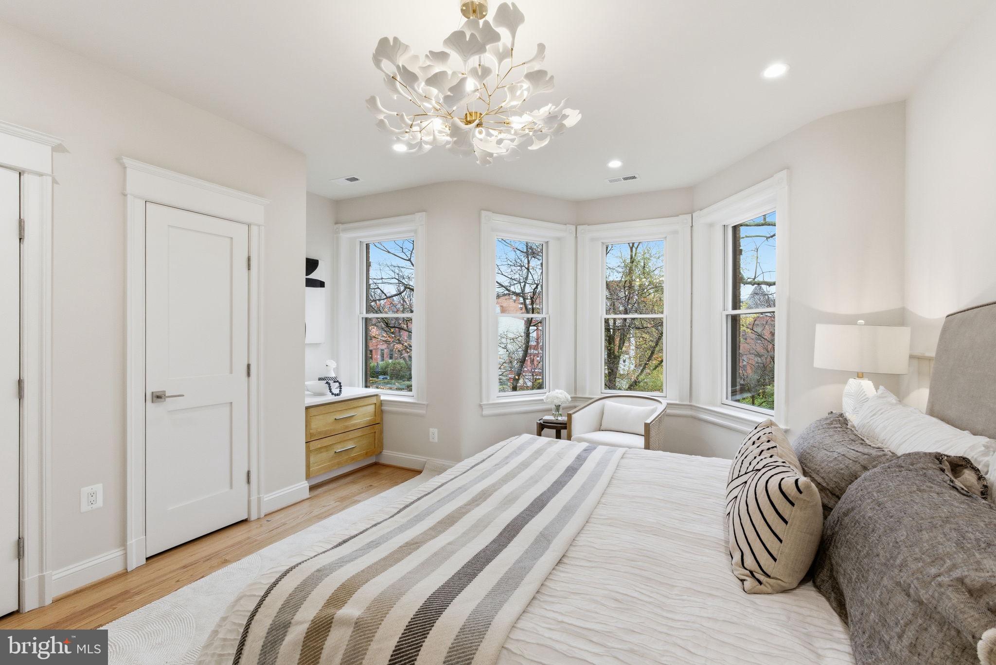 1319 East Capitol Street Southeast Washington, DC 20003 - Photo 23 of 46 a bedroom with a large bed and a chandelier
