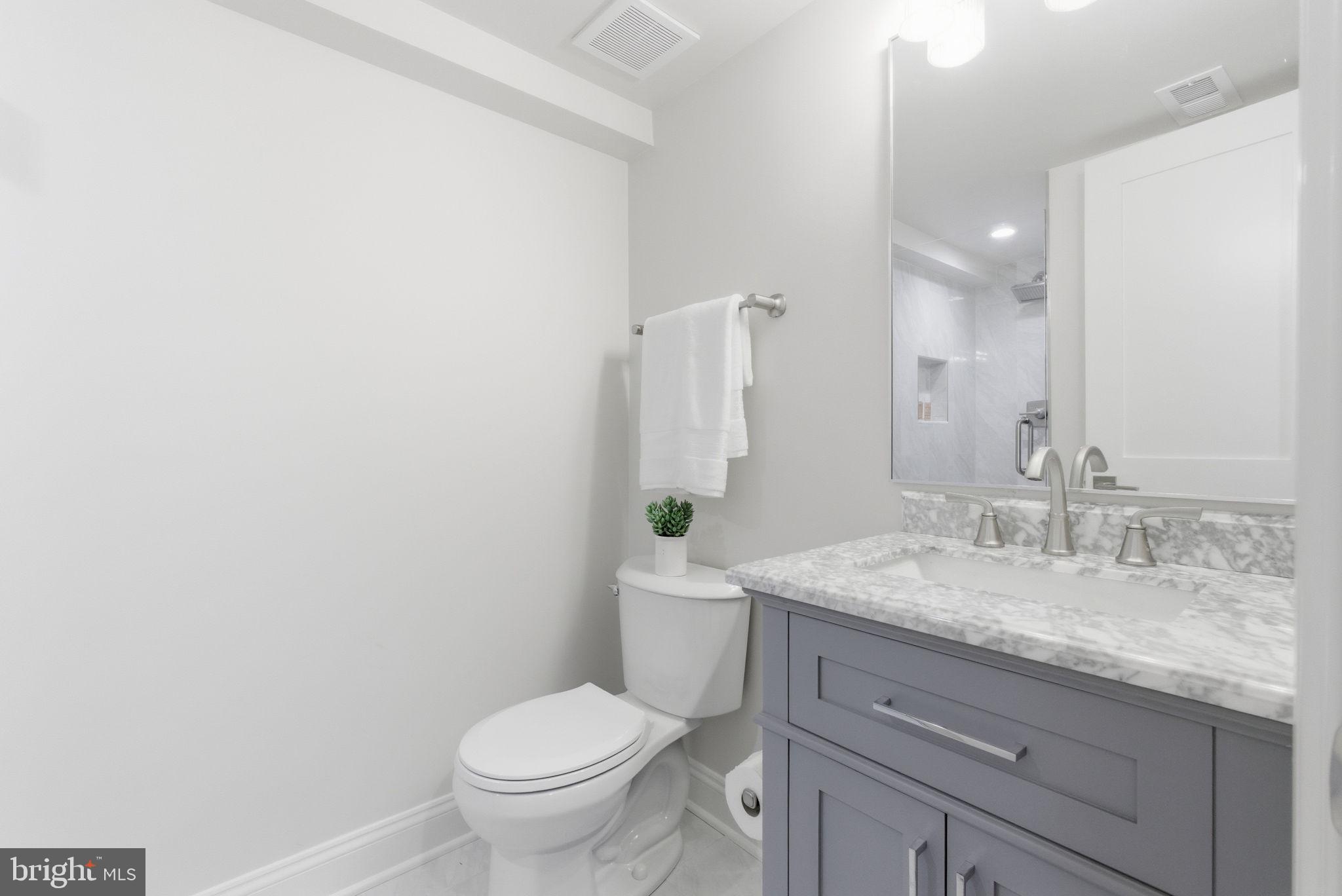 1319 East Capitol Street Southeast Washington, DC 20003 - Photo 37 of 46 a bathroom with a granite countertop toilet sink and mirror