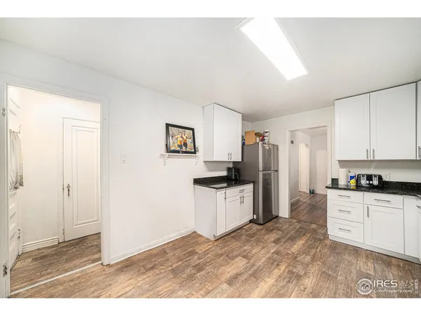a kitchen with granite countertop a refrigerator stove top oven and sink
