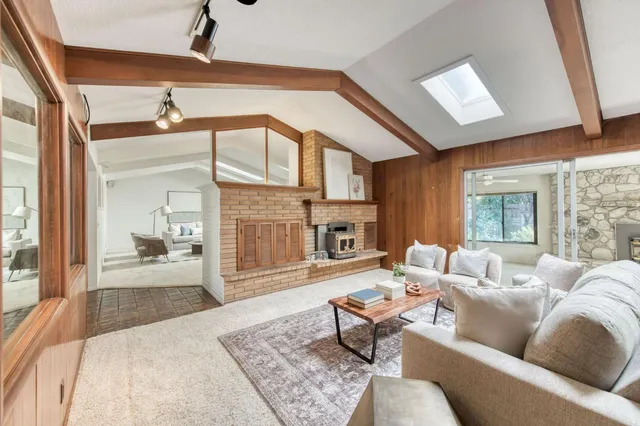 a living room with furniture a wooden floor and next to a window