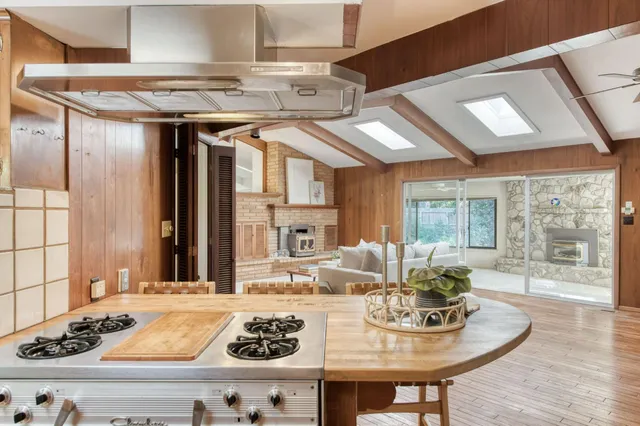 an empty room with windows and fireplace