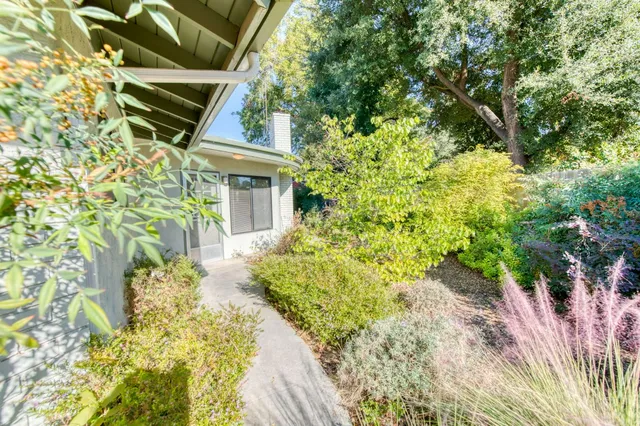 an aerial view of residential houses with outdoor space and trees