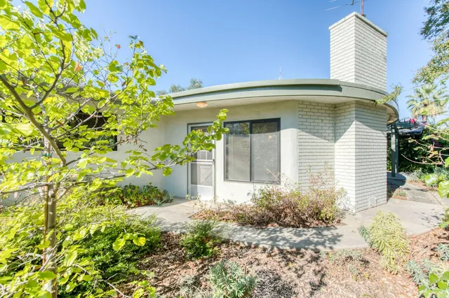an aerial view of a house with a yard and large trees
