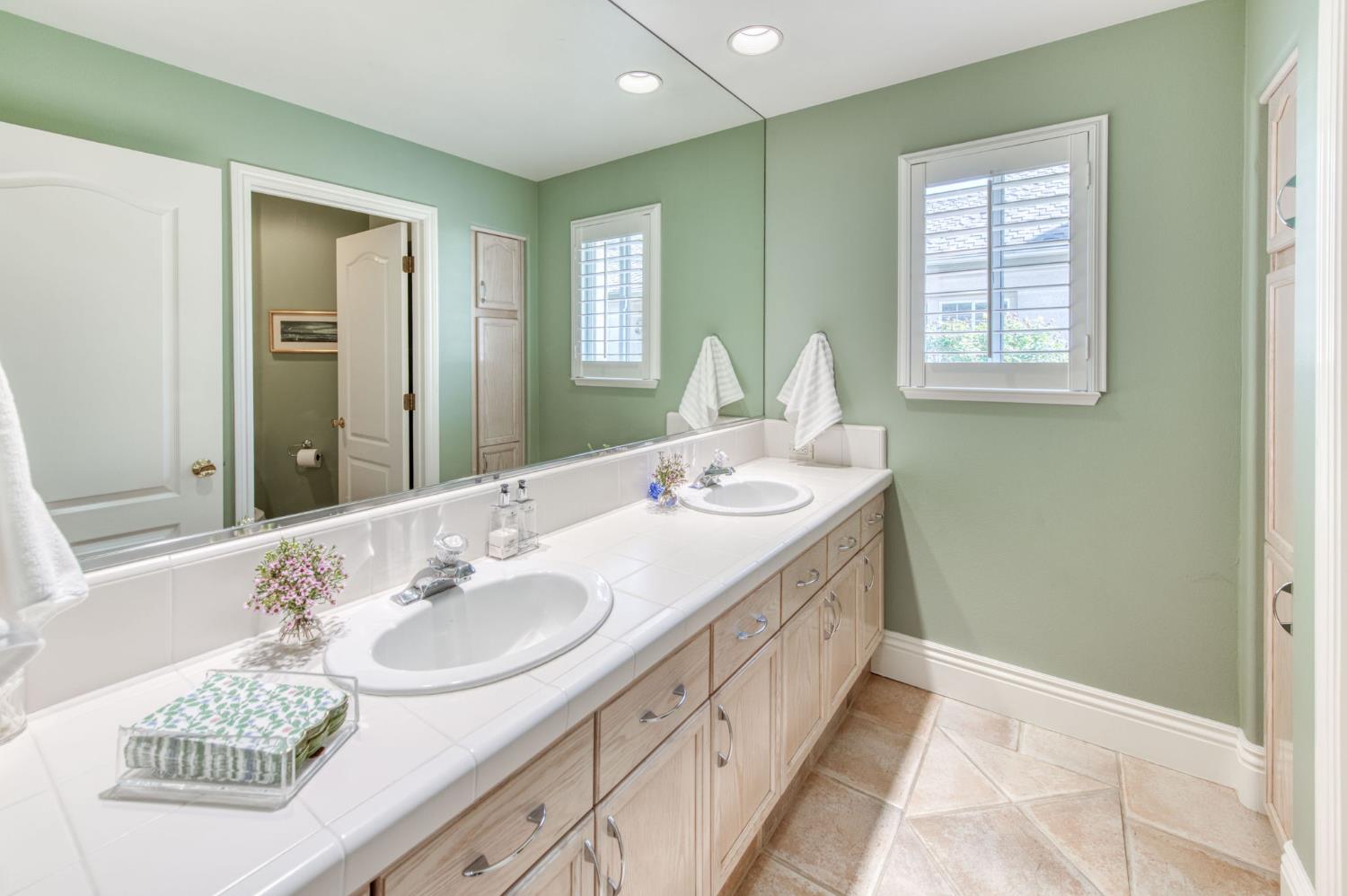 3063 West Pembrook Loop Fresno, CA 93711 - Photo 28 of 52 a bathroom with a granite countertop sink and a mirror