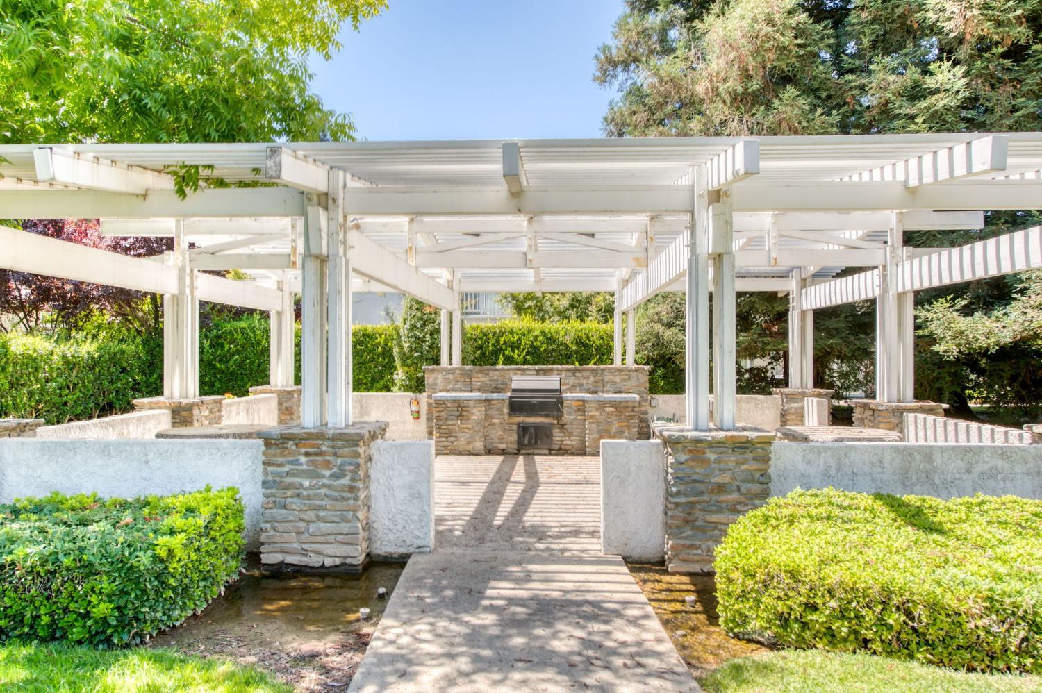 3063 West Pembrook Loop Fresno, CA 93711 - Photo 52 of 52 a view of a patio with table and chairs potted plants and large tree