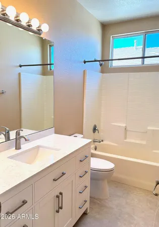 a bathroom with a granite countertop sink toilet and mirror