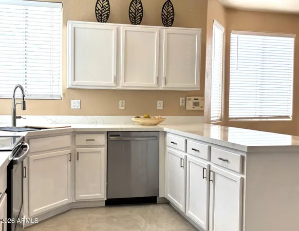a kitchen with stainless steel appliances white cabinets and a sink
