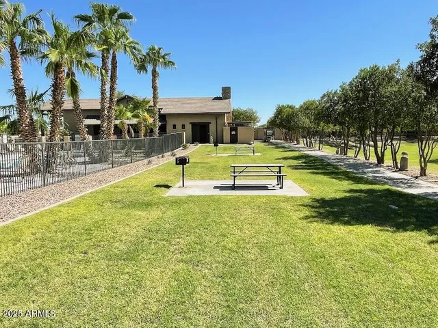 a view of house with swimming pool and tall trees