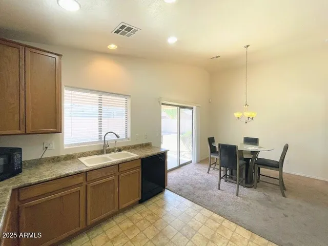 a kitchen with a dining table chairs and white cabinets