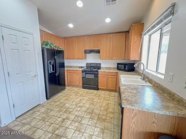 a kitchen with stainless steel appliances granite countertop a refrigerator sink and cabinets
