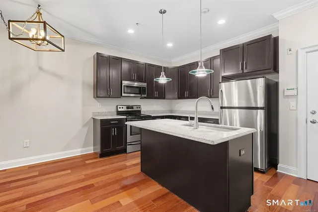 a kitchen with kitchen island a sink stainless steel appliances and cabinets