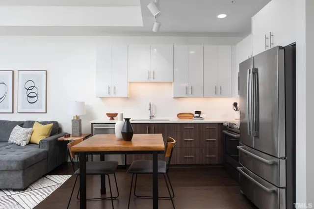 a kitchen with a refrigerator and wooden cabinets