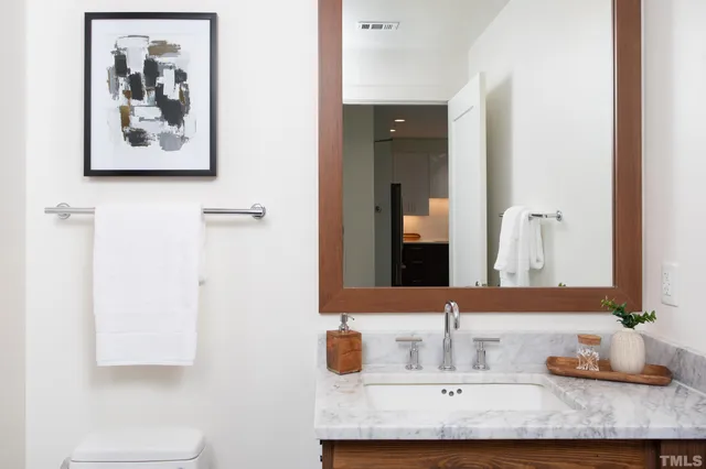 a bathroom with a granite countertop sink and a mirror