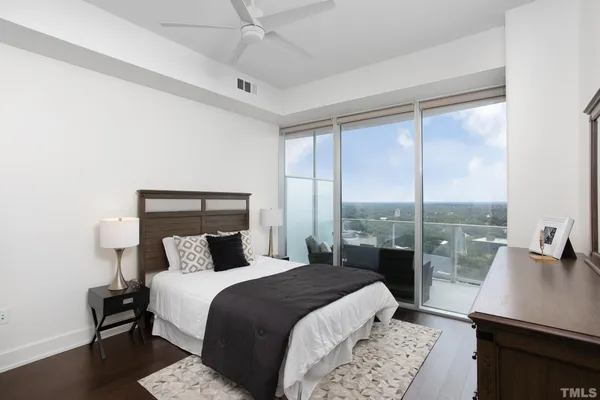 a bedroom with a bed a table and a large window