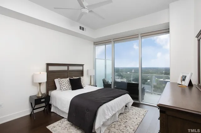 a bedroom with a bed a table and a large window