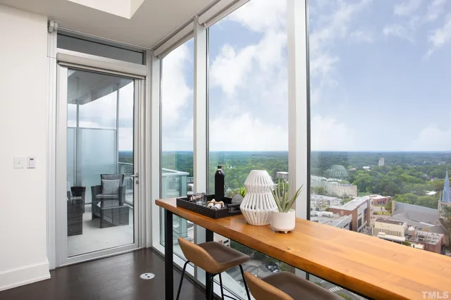 a dining room with furniture and a floor to ceiling window