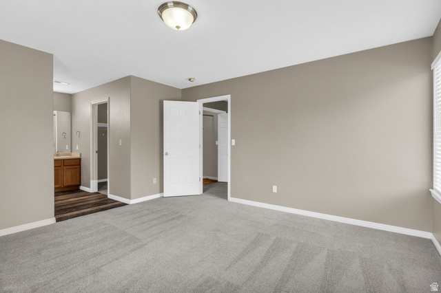 656 South 910 West, Unit 25 Pleasant Grove, UT 84062 - Photo 13 of 25 Spacious ensuite primary bedroom featuring neutral carpeting, soft light-toned walls, and crisp white trim for a bright and inviting feel.