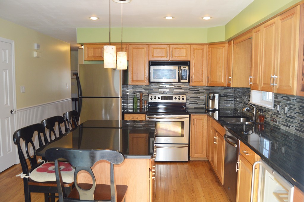 19 Birch Road Cumberland, RI 02864 - Photo 5 of 24 a kitchen with stainless steel appliances granite countertop a refrigerator a stove top oven a sink and dishwasher