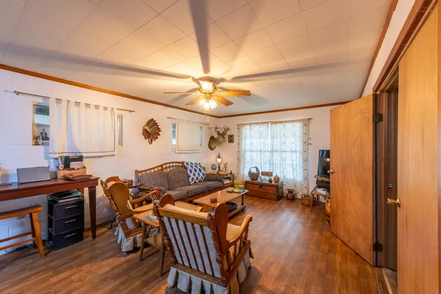 a living room with lots of furniture kitchen view and a chandelier