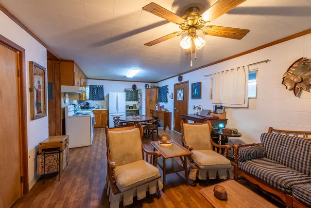 a kitchen with stainless steel appliances granite countertop a refrigerator a stove and a dining table with wooden floor