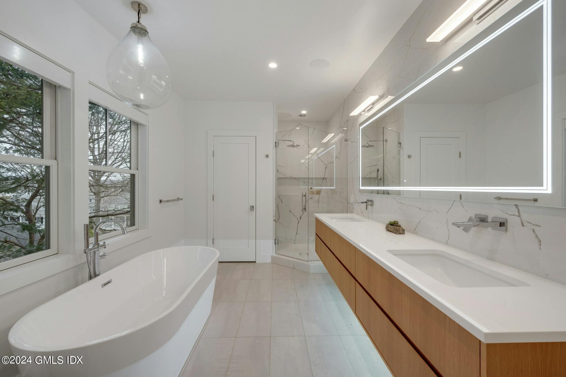 26 Chapel Lane Riverside, CT 06878 - Photo 18 of 35 a bathroom with a tub double vanity sink and mirror