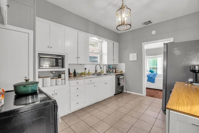 a large white kitchen with cabinets