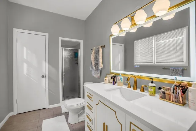 a bathroom with a sink a toilet and a mirror