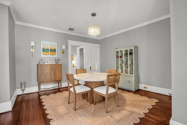 a dining room with wooden floor and a rug