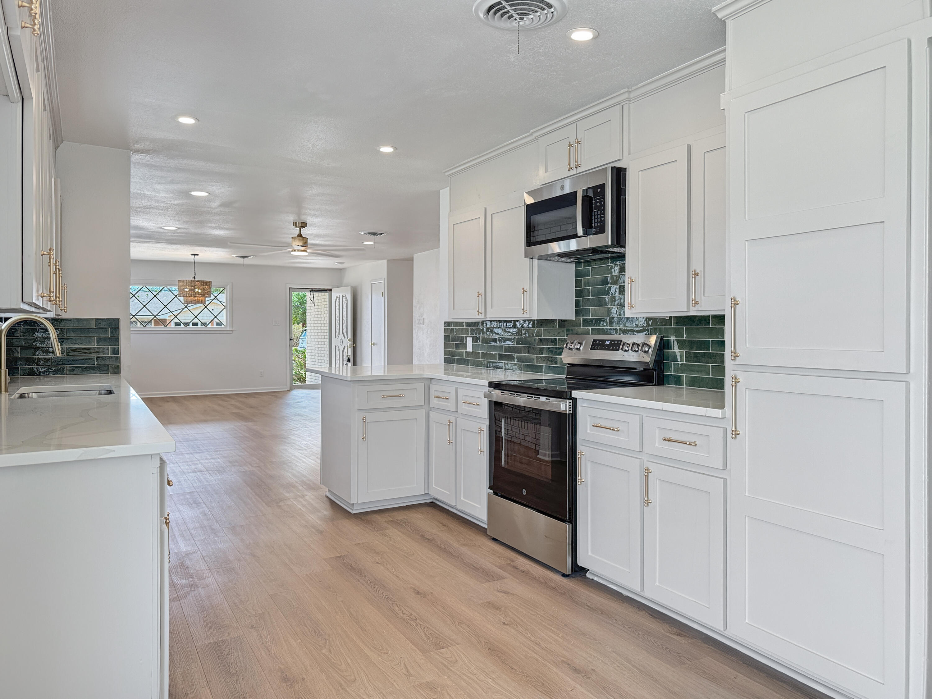 5502 8th Street Lubbock, TX 79416 - Photo 11 of 41 a kitchen with granite countertop white cabinets and stainless steel appliances