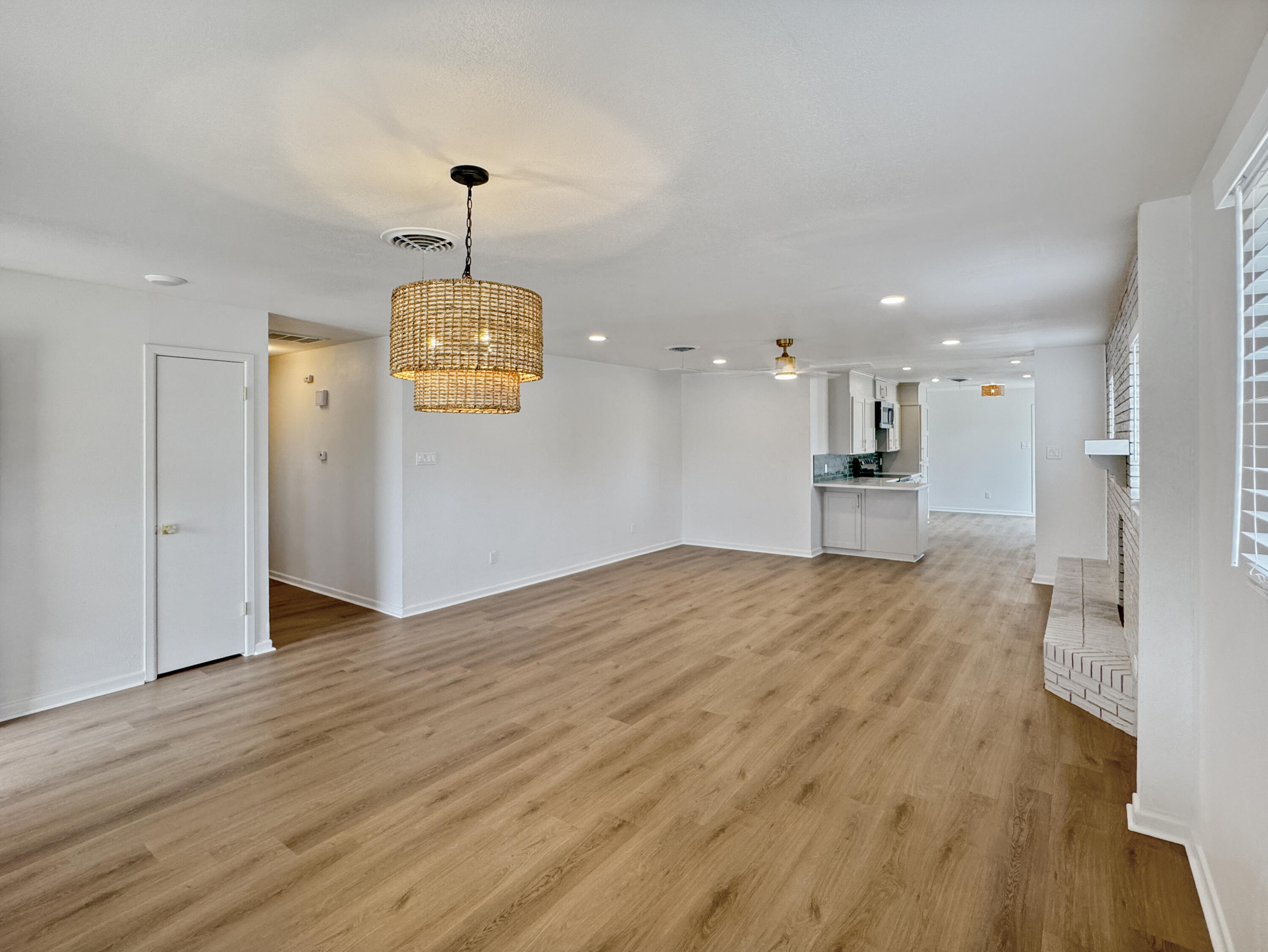 5502 8th Street Lubbock, TX 79416 - Photo 21 of 41 a view of empty room with wooden floor and kitchen view