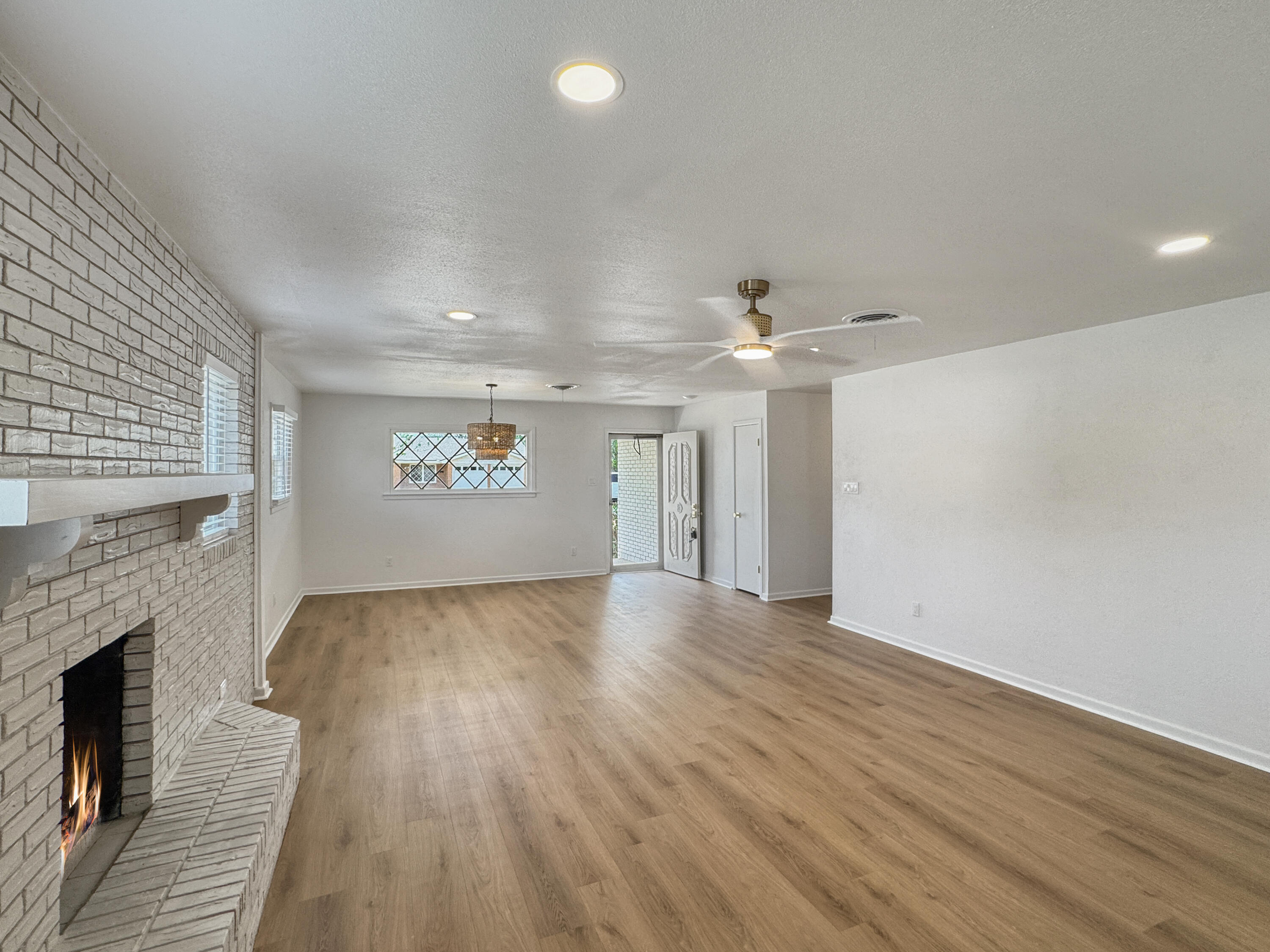 5502 8th Street Lubbock, TX 79416 - Photo 24 of 41 an empty room with wooden floor fireplace and windows