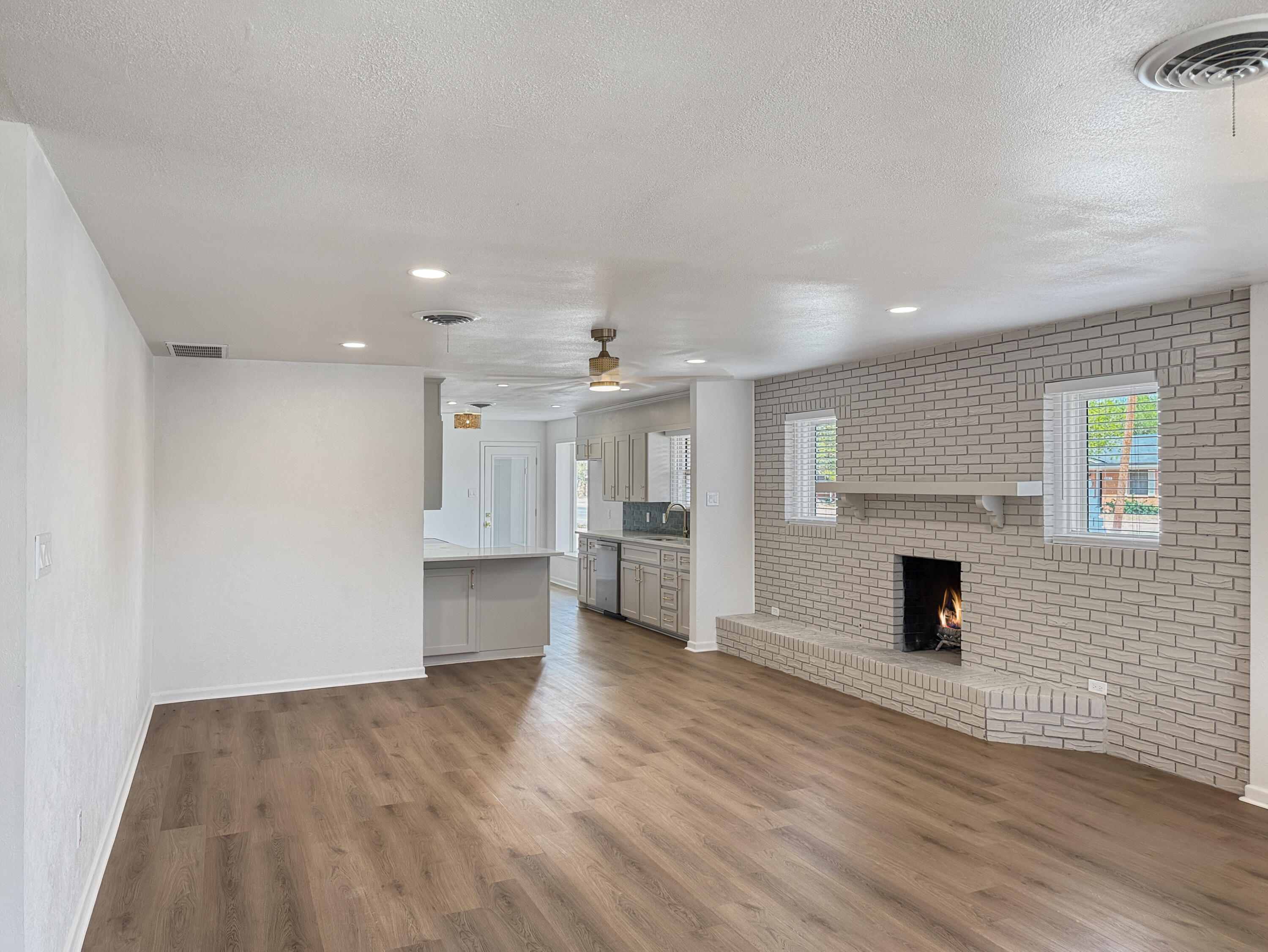 5502 8th Street Lubbock, TX 79416 - Photo 26 of 41 an empty room with wooden floor fireplace and windows