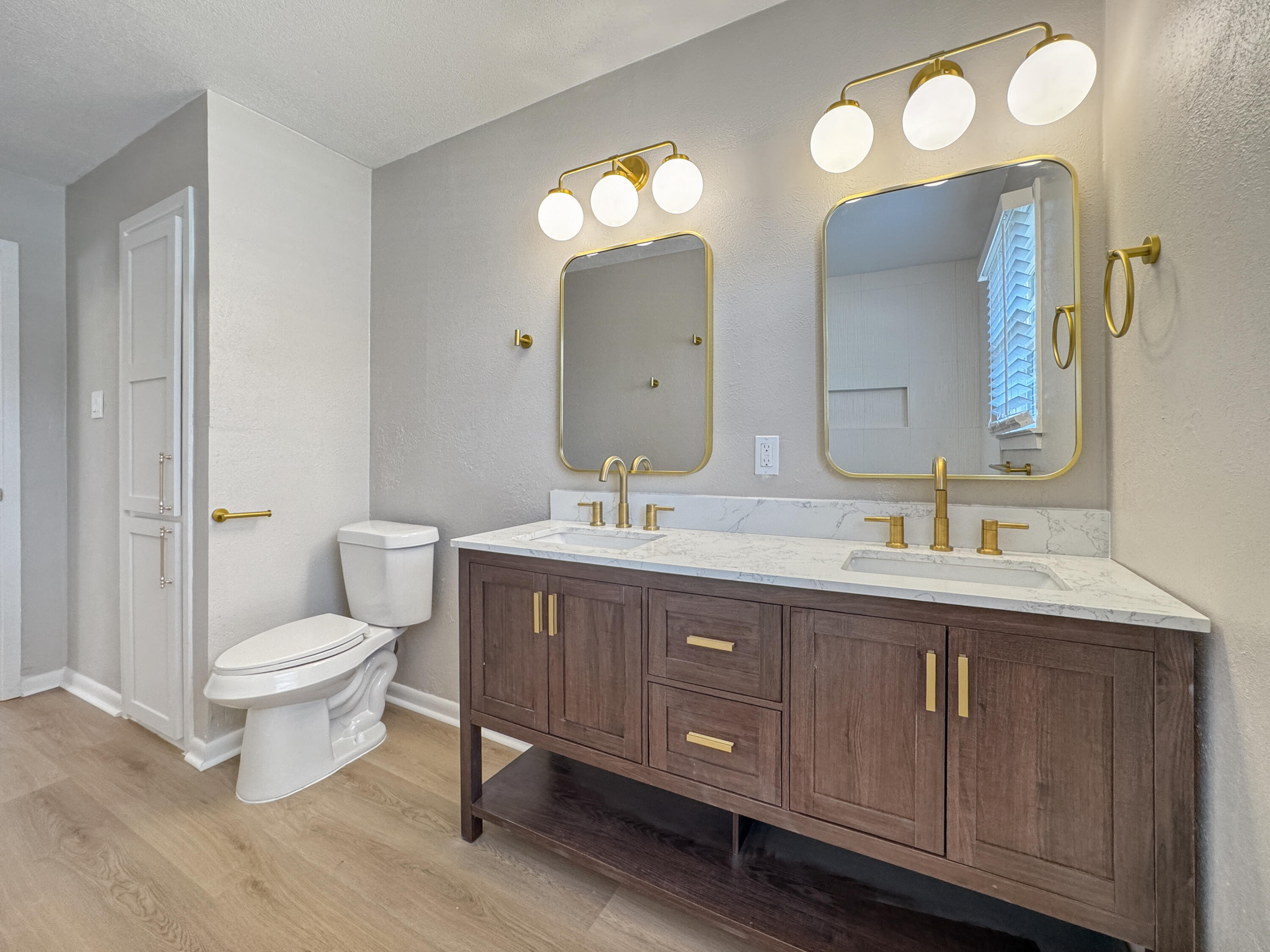 5502 8th Street Lubbock, TX 79416 - Photo 27 of 41 a bathroom with a double vanity sink and a toilet