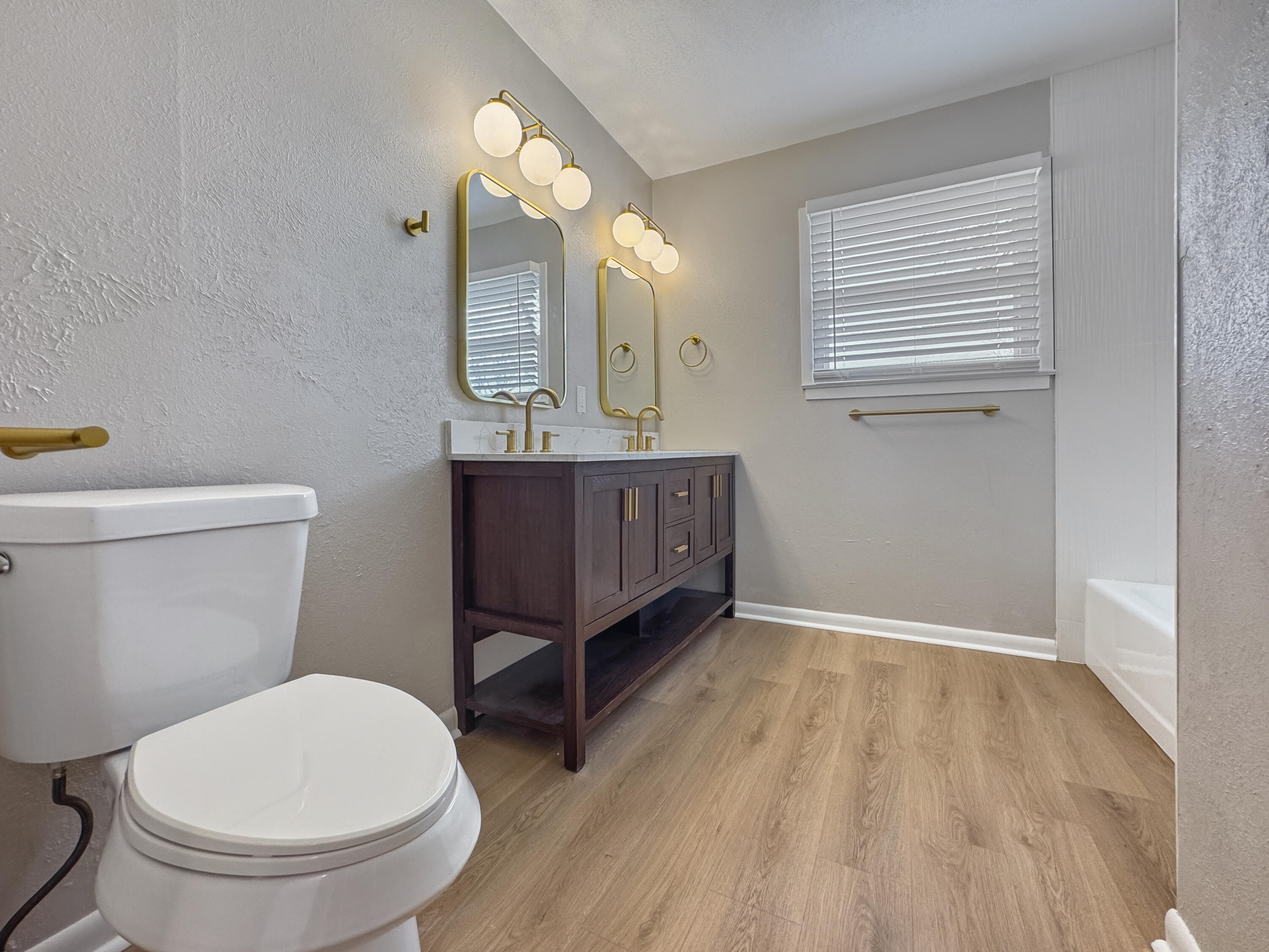 5502 8th Street Lubbock, TX 79416 - Photo 29 of 41 a bathroom with a toilet a sink and mirror