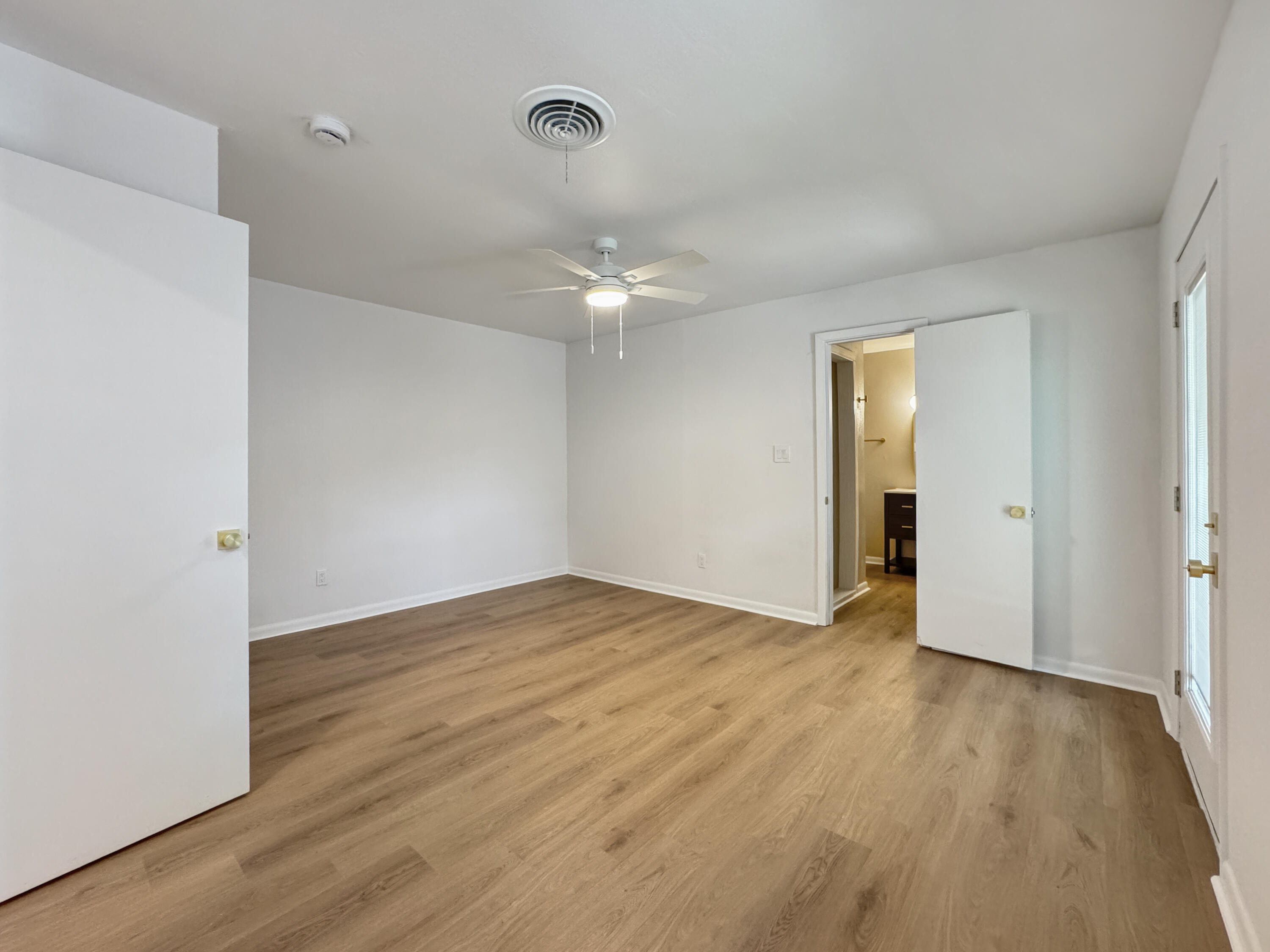 5502 8th Street Lubbock, TX 79416 - Photo 34 of 41 a view of an empty room with wooden floor and a ceiling fan