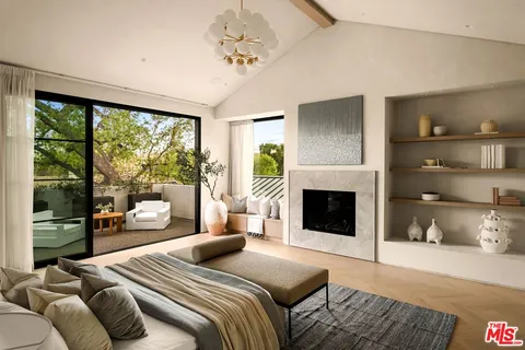 a bedroom with a large bed and a fireplace