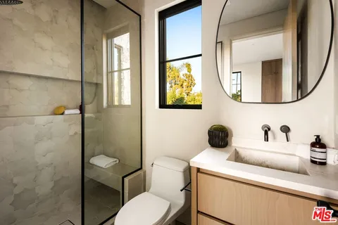 a bathroom with a toilet sink and mirror
