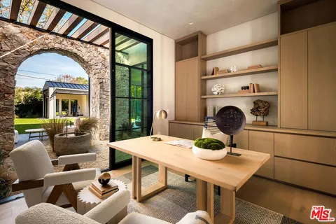 a living room with furniture a fireplace and a floor to ceiling window