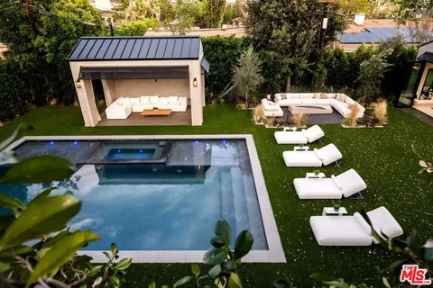 a view of swimming pool with a yard chairs and a fire pit