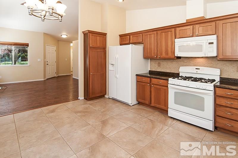 7716 Pickering Circle Reno, NV 89511 - Photo 3 of 15 a kitchen with stainless steel appliances a stove a refrigerator and cabinets
