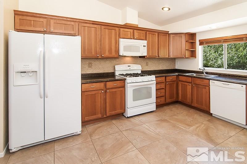 7716 Pickering Circle Reno, NV 89511 - Photo 4 of 15 a kitchen with stainless steel appliances granite countertop a stove a sink and a refrigerator