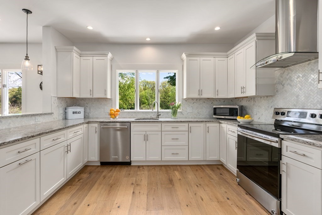 338 South Great Road Lincoln, MA 01773 - Photo 6 of 29 a kitchen with stainless steel appliances granite countertop white cabinets granite counter tops and a hard wood floors