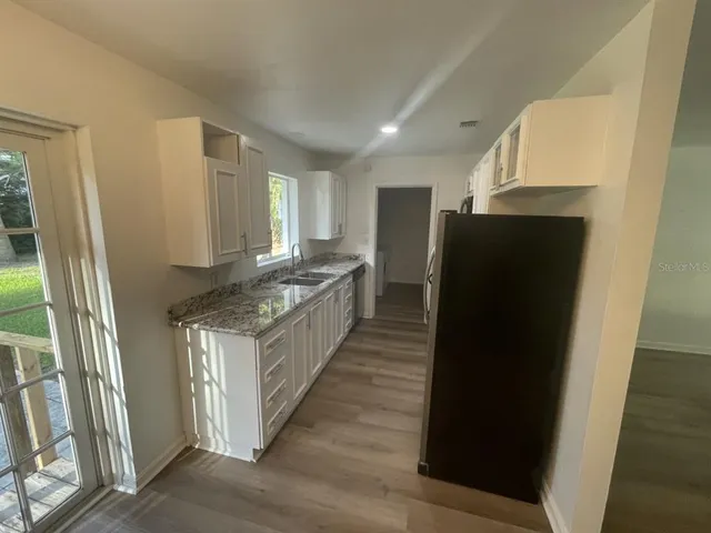 a kitchen with stainless steel appliances granite countertop a refrigerator a sink and a stove