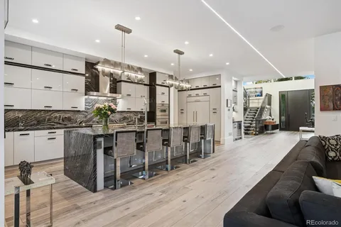 a large white kitchen with lots of counter space and stainless steel appliances