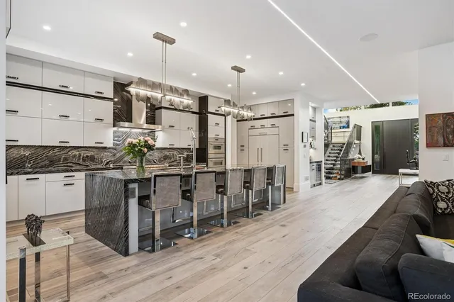 a large white kitchen with lots of counter space and stainless steel appliances