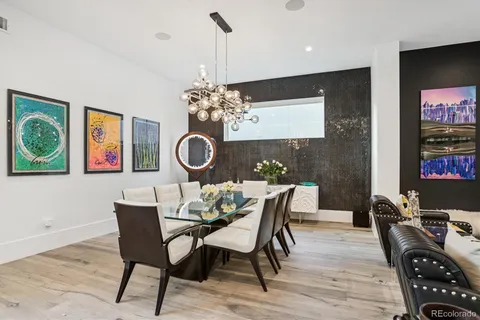 a dining room with furniture a chandelier and wooden floor