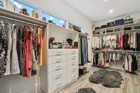 a view of walk in closet with clothes and shoes